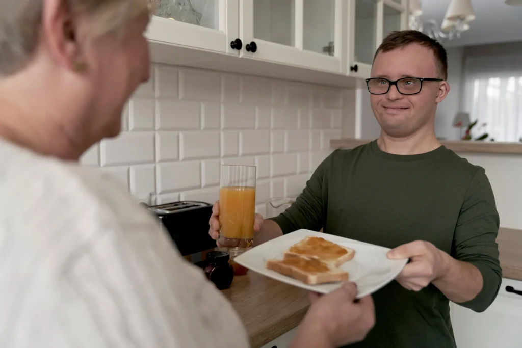 Disabled man making breakfast with support worker