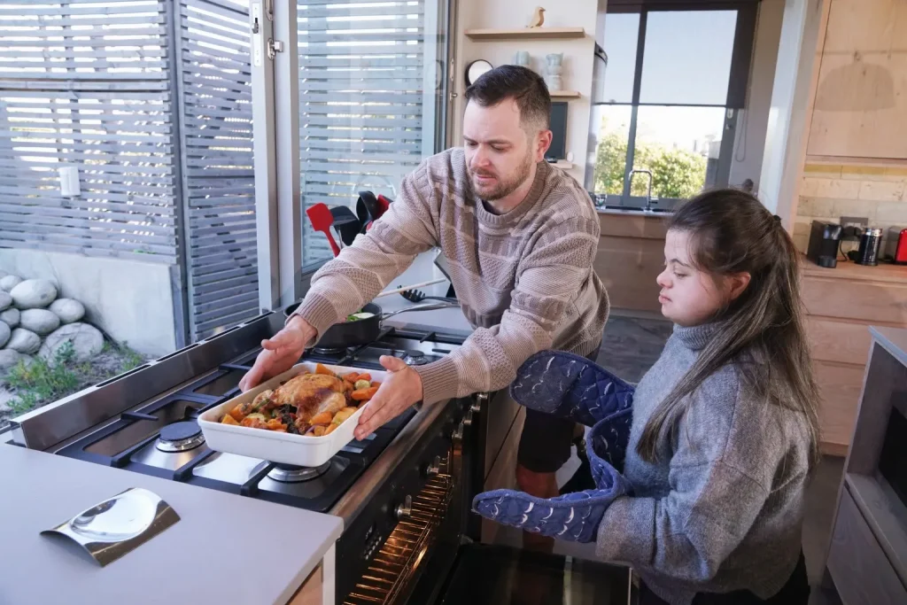 Disabled woman cooking a roast with support worker