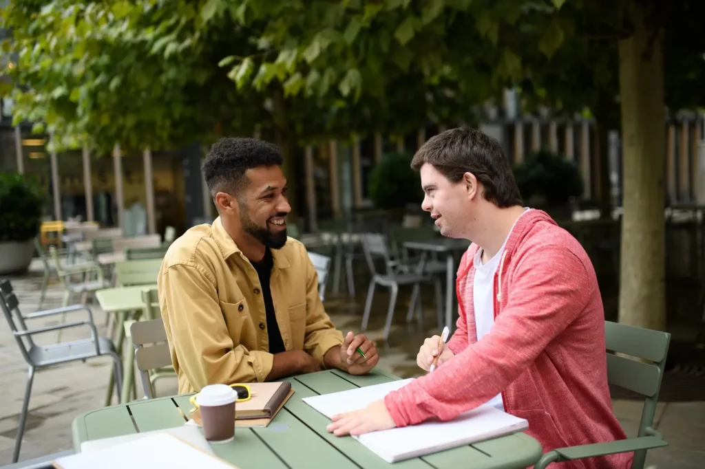 Disabled man with support worker smiling at each other